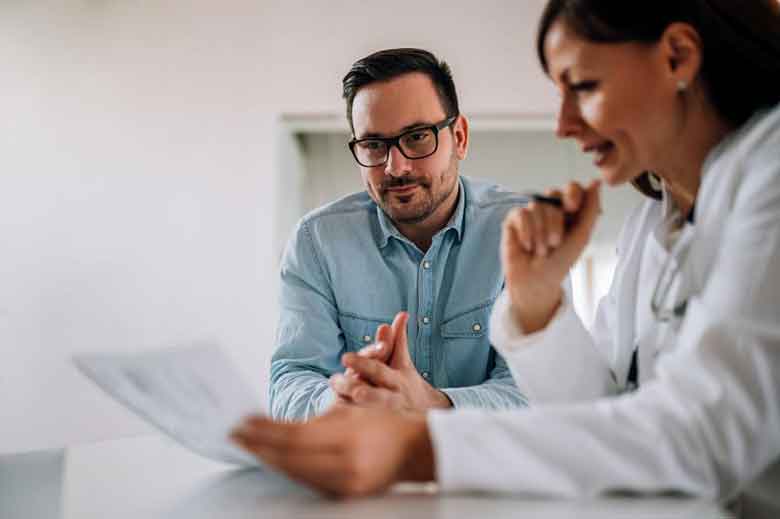 Doctor With the Patient Examining the Report